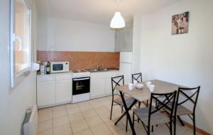 Una cocina con una mesa y sillas en una cocina. en 2 Bedroom Cozy Home In Lablachère, en Lablachère