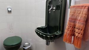 a bathroom with a green toilet and a green urinal at Recanto Amana – Casa Completa no Centro de SJBV in São João da Boa Vista