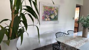 a dining room with a table and a plant at Recanto Amana – Casa Completa no Centro de SJBV in São João da Boa Vista +48 photos