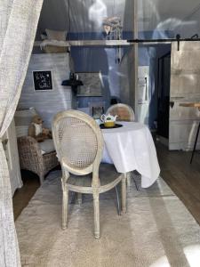 a dining table with two chairs and a white table cloth at Le Studio de Sosso in Aniane