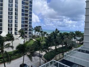 a view of the beach from the balcony of a resort at Sunny Isles Oceanfront Apartment for Two in Sunny Isles Beach