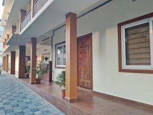 a hallway of a building with a wooden door at Haya podes in Vypīn