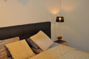 a bed with a black headboard and two pillows at FREDNES COSY RETREAT - One Bedroom Apartment in Porsgrunn