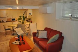 a living room with a red couch and a table at FREDNES COSY RETREAT - One Bedroom Apartment in Porsgrunn
