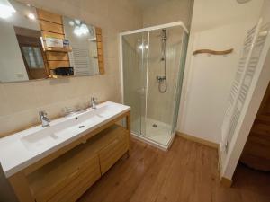 um banheiro com pia e chuveiro em Rocher du Cerf skis aux pieds 3 ch 2 sdb em Le Lioran mais 29 fotografias