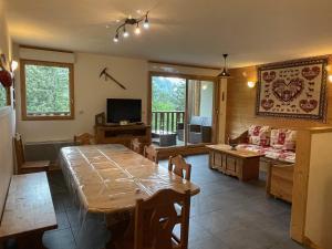 uma sala de estar com uma mesa e um sofá em Rocher du Cerf skis aux pieds 3 ch 2 sdb em Le Lioran