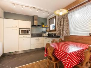 a kitchen with a table with a red and white table cloth at Appartement 2 chambres centre village proche pistes avec Wifi - FR-1-437-60 in La Clusaz +6 photos