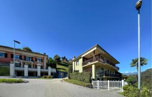 a building with a white fence next to a street at 2 Bedroom Awesome Apartment In Omegna in Omegna