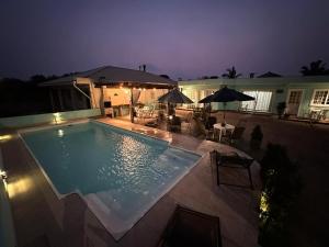 a swimming pool at night with tables and umbrellas at 02 -CASA Praia PINHEIRA in Palhoça +15 photos
