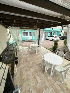 a patio with a table and chairs and a grill at 02 -CASA Praia PINHEIRA in Palhoça