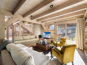 ein Wohnzimmer mit Sofa, Sesseln und Fernseher in der Unterkunft Chalet spacieux près des pistes avec sauna et WiFi, animaux admis - FR-1-567-69 in Val dʼIsère