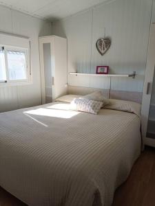 a bedroom with a large white bed with a heart on the wall at Acogedora casa de invitados in Hinojos