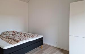 une chambre avec un lit dans une pièce blanche dans l'établissement 3 Bedroom Beautiful Home In Løkken, à Trudslev