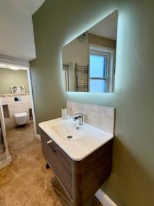 a bathroom with a sink and a mirror at The Roman Kove Apartment Bath in Bath +48 photos