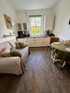 a living room with a couch and a table at The Roman Kove Apartment Bath in Bath