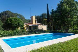a swimming pool in front of a house at Oasis in Villa Anizacate