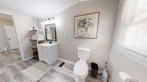 a bathroom with a toilet and a sink and a mirror at 3 Bed 2 bath Pet Friendly in Historic Bates Hendricks in Indianapolis +19 photos