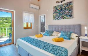 a bedroom with a large bed with blue and yellow pillows at Nice Home In Murter With Private Swimming Pool, Can Be Inside Or Outside in Murter