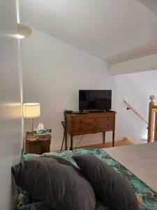 a bedroom with a bed and a flat screen tv at La Tour Noble in Saint-Saturnin