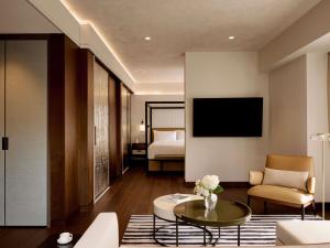 a living room with a couch and a table at Fairmont Golden Prague in Prague