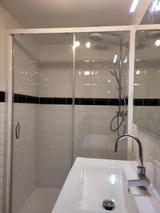 a white bathroom with a shower and a sink at Les Combes avec piscine chauffée au nord Sarlat in LʼAir
