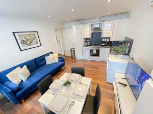 a living room with a blue couch and a table at Embankment 2-Bed Flat with AC near Charing Cross, Trafalgar Square, London Eye, Big Ben in London