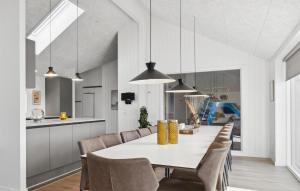 a kitchen and dining room with a white table and chairs at Cozy Home In Bogense With Sauna in Skåstrup