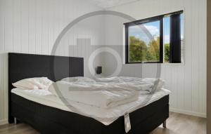 Fjellerup Strandにある6 Bedroom Awesome Home In Glesborgの大きな窓付きのベッドルームのベッド1台 +1枚の写真