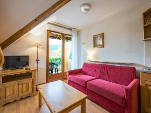 a living room with a red couch and a table at Birdie E N23 - ST4 in Giez