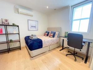 a bedroom with a bed and a desk and a chair at Embankment 2-Bed Flat with AC near Charing Cross, Trafalgar Square, London Eye, Big Ben in London +12 photos