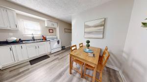 a kitchen with white cabinets and a wooden table and chairs at 3 Bed 2 bath Pet Friendly in Historic Bates Hendricks in Indianapolis