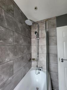 a bath tub with a shower in a bathroom at The Walnut in Aveley +78 photos