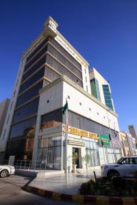 a tall building with a car parked in front of it at Al Muhaidb Residence Salahuddin in Riyadh