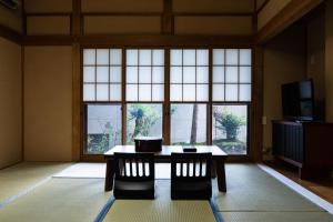 Una habitación con una mesa y sillas y una ventana grande. en 春日光 HaruNikko Guesthouse, en Nikko
