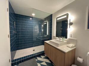 a bathroom with a sink and a shower with blue tiles at NEW luxury suite Miami at the WorldCenter area - Great views in Miami