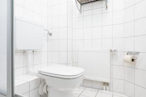 a white bathroom with a toilet and a shower at Nautic W13 in Laboe +16 photos