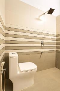 a bathroom with a white toilet and a shower at Tranquil Gudalur Stay Surrounded by Tea & Forests in Gūdalūr +45 photos