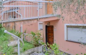 a pink building with a door and a balcony at 1 Bedroom Awesome Apartment In San Saturnino in Bracco