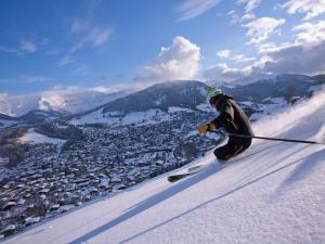 a man is skiing down a snow covered slope at Appartement 3 pièces avec balcon, cheminée et parking – À 400m des pistes et du golf, Megève Mont d'Arbois - FR-1-453-254 in Megève