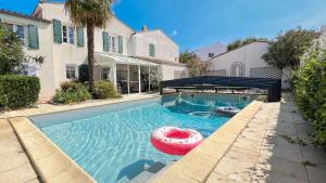 Una piscina con una mesa inflable roja. en Au calme, villa avec piscine, en La Flotte
