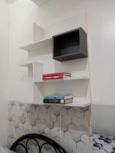 a shelf with a television and books on it at 2 Bedroom Condo in AMAIA STEPS NOVALICHES in Manila