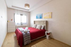 ein Schlafzimmer mit einem roten Bett mit einer roten Decke in der Unterkunft Studio chic et paisible avec piscine parc et plage in Aïn Harrouda + 12 Fotos