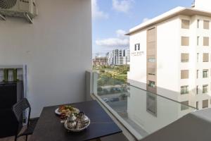 einen Balkon mit einem Tisch und Blick auf ein Gebäude in der Unterkunft Studio chic et paisible avec piscine parc et plage in Aïn Harrouda