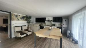 ein Wohnzimmer mit Tisch und Küche in der Unterkunft Le Clos du Roc d'Azur Suite climatisée , terrasses privées, piscine, parking sécurisé in Roquefort-les-Pins
