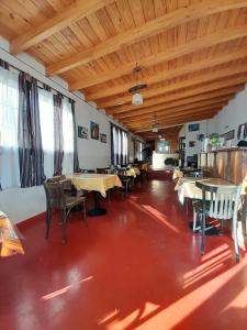 Un comedor con mesas y sillas y techos de madera. en Hostería El Encanto - Ubicación céntrica, en Tilcara
