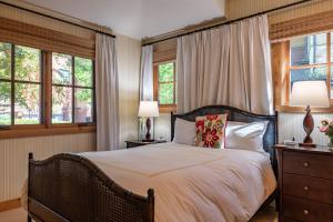 een slaapkamer met een bed met 2 lampen en ramen bij Angani Way Townhome 104 in Elkhorn Village +47 foto's