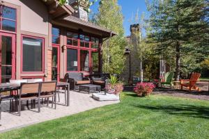 een patio met stoelen en tafels op een gazon bij Angani Way Townhome 104 in Elkhorn Village