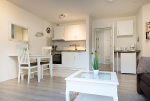 a living room with a white table and a kitchen at Nautic W08 in Laboe