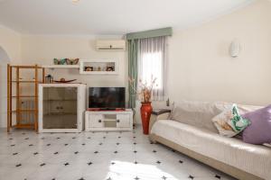 un soggiorno con un divano e una TV di Villa Paraiso para 4 a Miami Platja