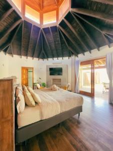 a bedroom with a large bed with a wooden ceiling at Atiaia Jungle River Retreat in Visconde De Maua